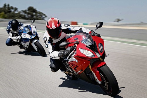 Image man in red and black motorcycle suit riding on red and white sports bike