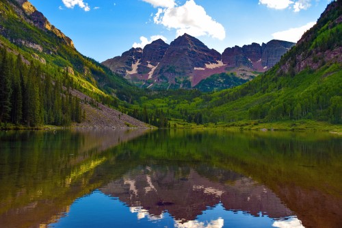 Image green mountains beside lake under blue sky during daytime