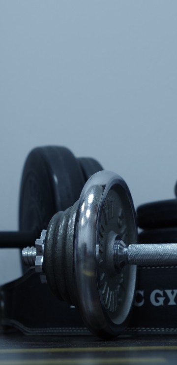 Image 2 black dumbbells on brown wooden table