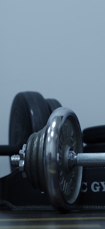Image 2 black dumbbells on brown wooden table