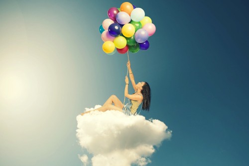 Image woman in white dress holding balloons