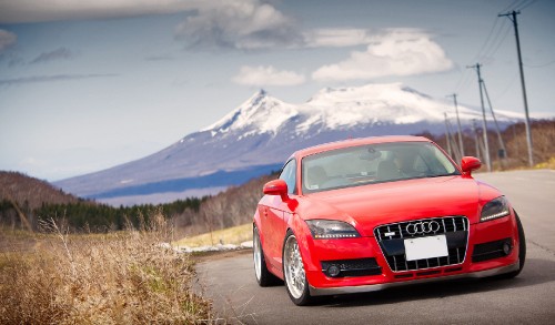 Image red audi r 8 on dirt road near mountain during daytime