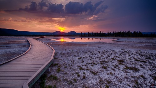 Image brown wooden dock on snow covered ground during sunset