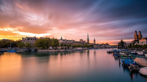 Image body of water near green trees and buildings during daytime