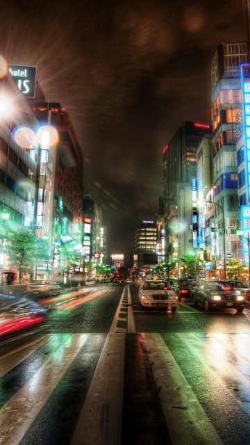 Image cars on road between high rise buildings during night time
