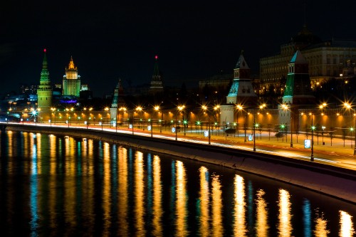 Image lighted city buildings near body of water during night time