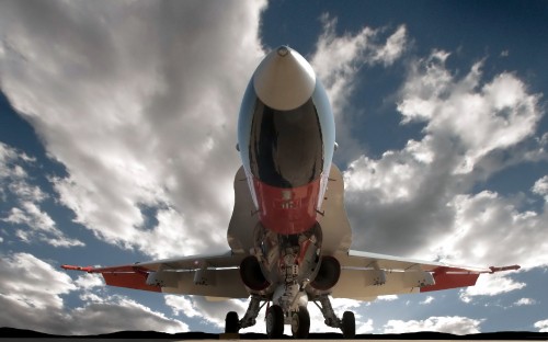 Image red and white airplane under blue sky and white clouds during daytime