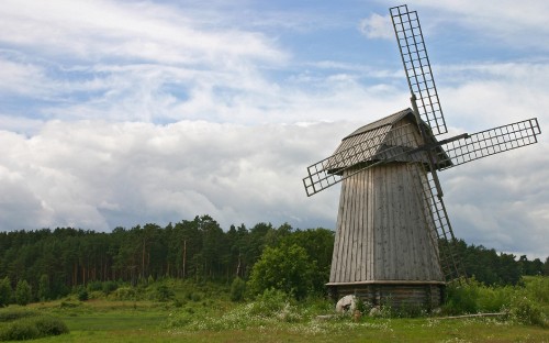 Image brown wooden house on green grass field under white clouds during daytime