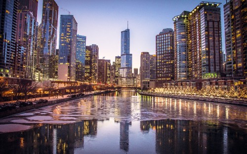 Image city skyline across body of water during night time