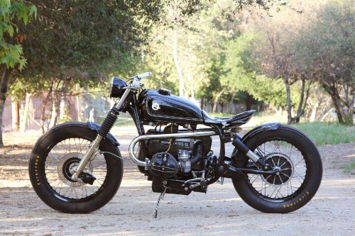 Image black standard motorcycle parked on gray concrete road during daytime