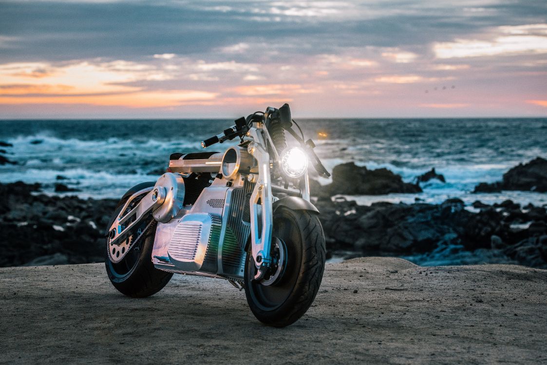 black and white sports bike on beach shore during sunset