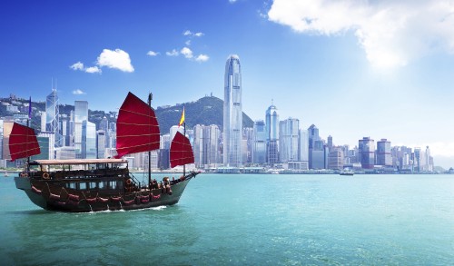 Image red and brown boat on sea near city buildings during daytime