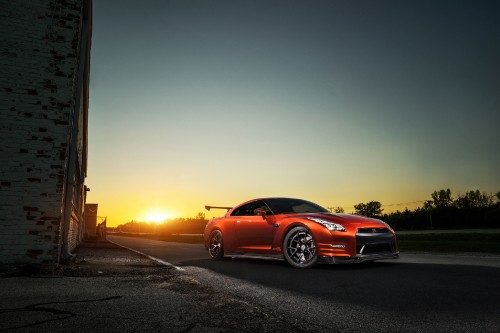 Image red sedan on road during sunset