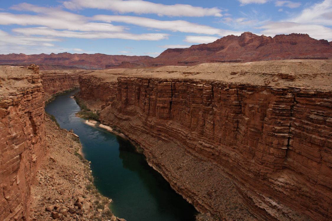 Braune Felsformation am See Tagsüber Beside. Wallpaper in 2711x1807 Resolution