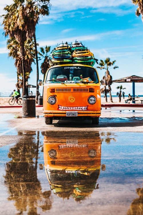 Image yellow and blue volkswagen t-2 van on gray concrete road during daytime