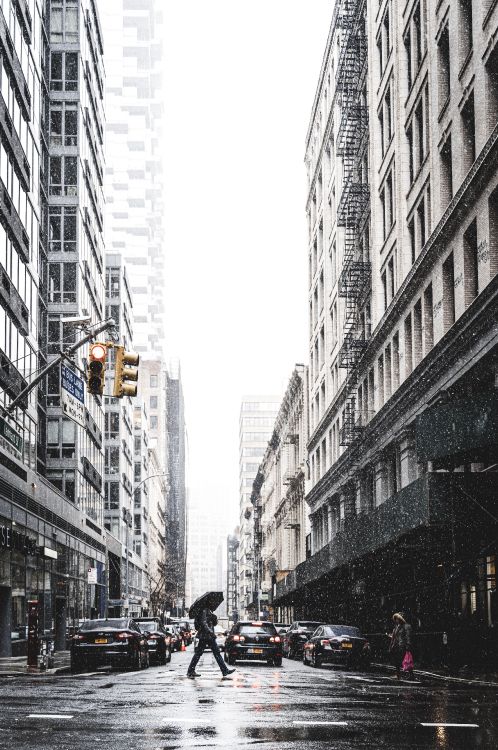 people walking on street between high rise buildings during daytime