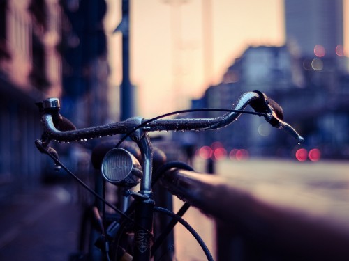 Image black bicycle in front of brown brick building during daytime