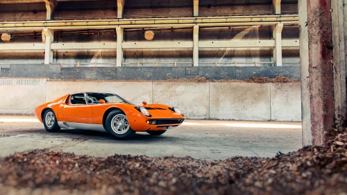 Image orange and black lamborghini aventador parked on gray concrete road during daytime