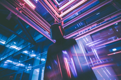 Image man in black hoodie standing in front of blue light