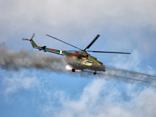 Image green and yellow helicopter flying in the sky