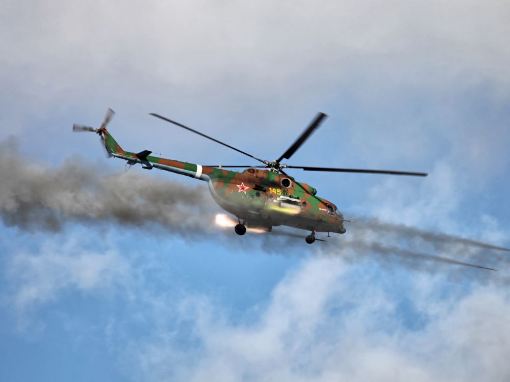 green and yellow helicopter flying in the sky