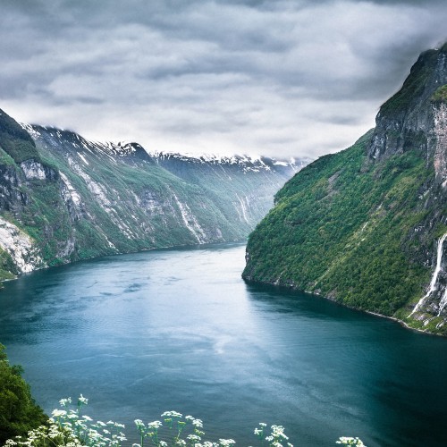 Image green lake between green mountains under gray clouds