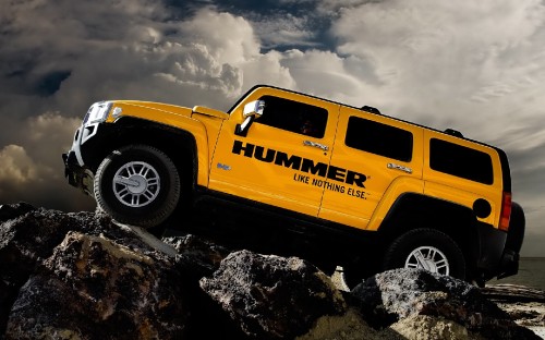 Image yellow chevrolet crew cab truck on rocky shore under cloudy sky during daytime