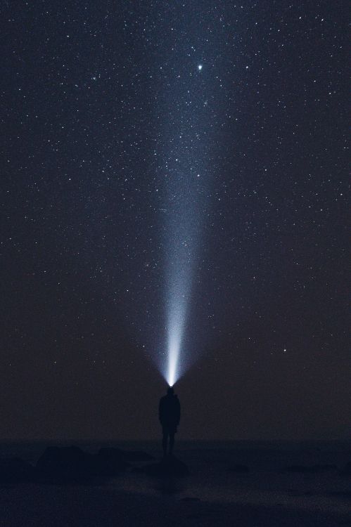 man in black jacket standing under starry night