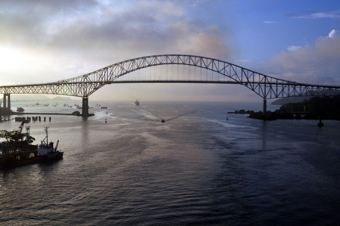 gray metal bridge over body of water during daytime