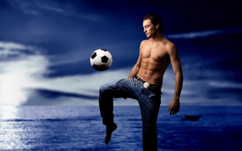 Image man in blue denim jeans holding soccer ball