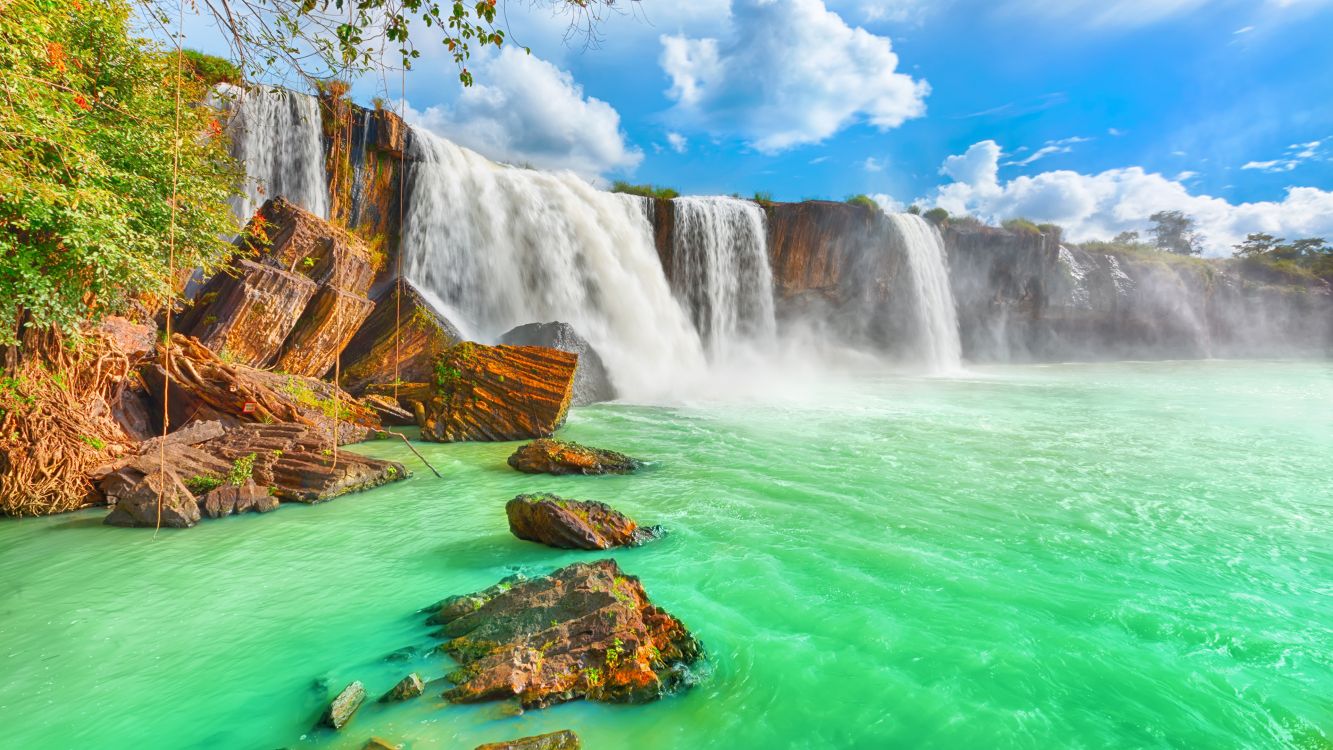 waterfalls under blue sky and white clouds during daytime