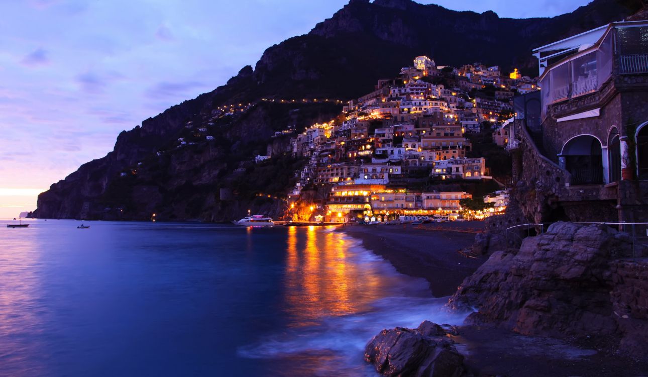 city lights on mountain near body of water during night time