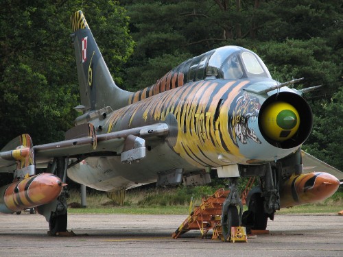 Image people walking near green and yellow fighter plane during daytime