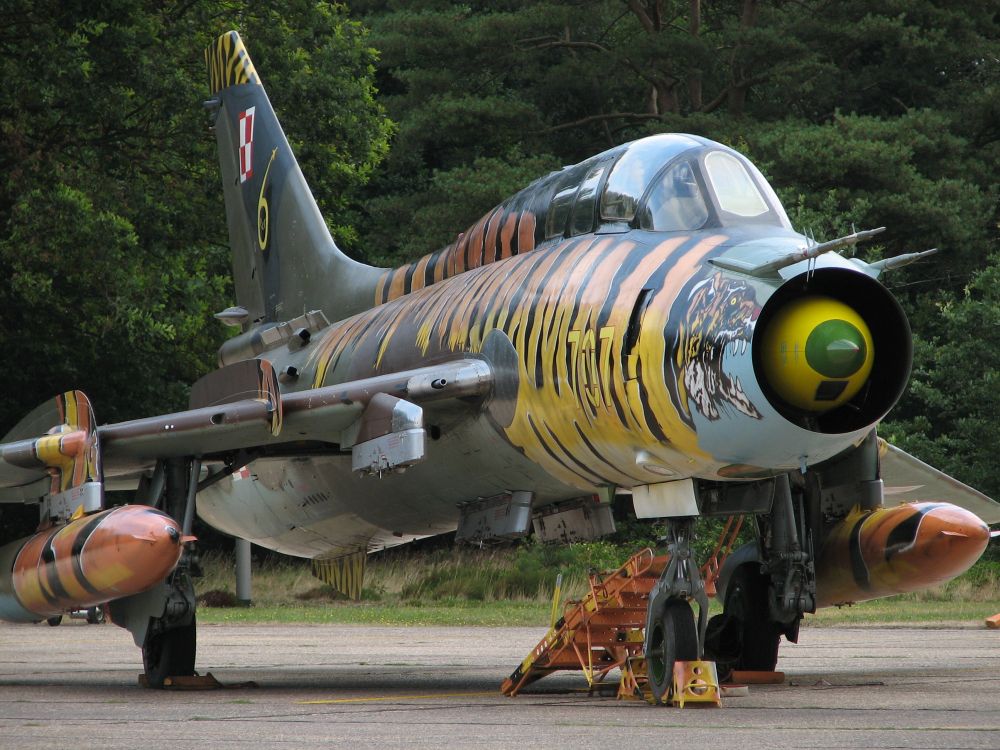 people walking near green and yellow fighter plane during daytime