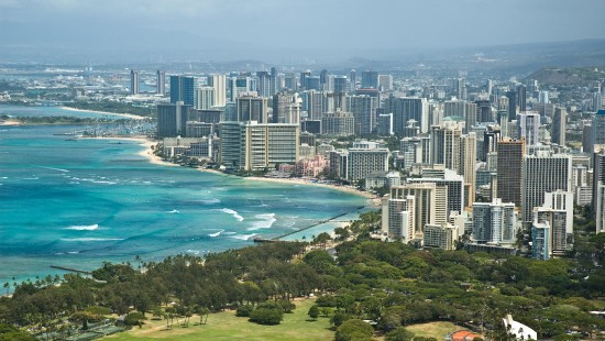 Image aerial view of city buildings near body of water during daytime