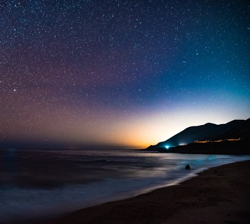 Image silhouette of mountain near body of water during night time