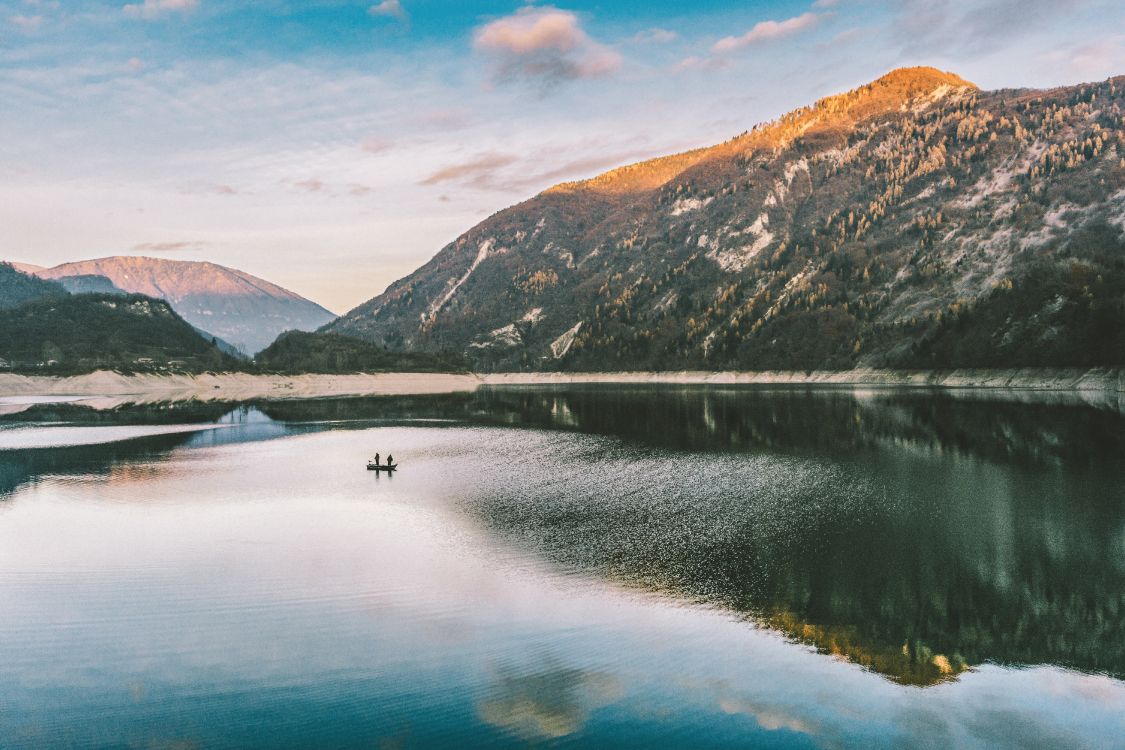 lake in the middle of green mountains during daytime