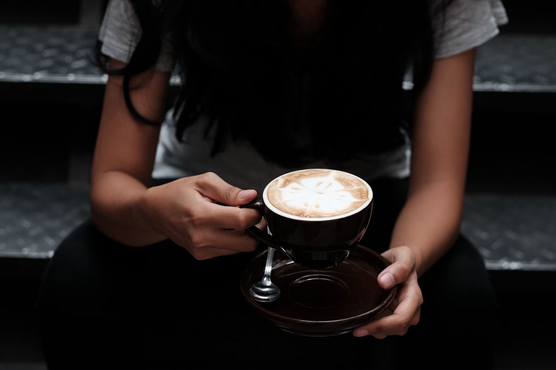 woman in black shirt holding cup of coffee