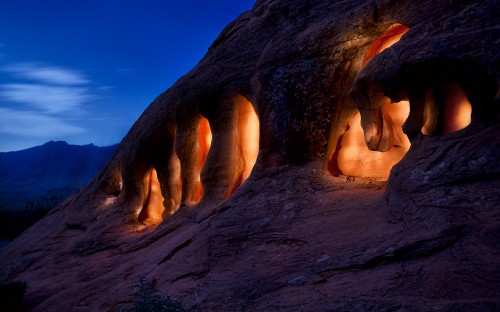 Image woman in black bikini sitting on rock formation during daytime