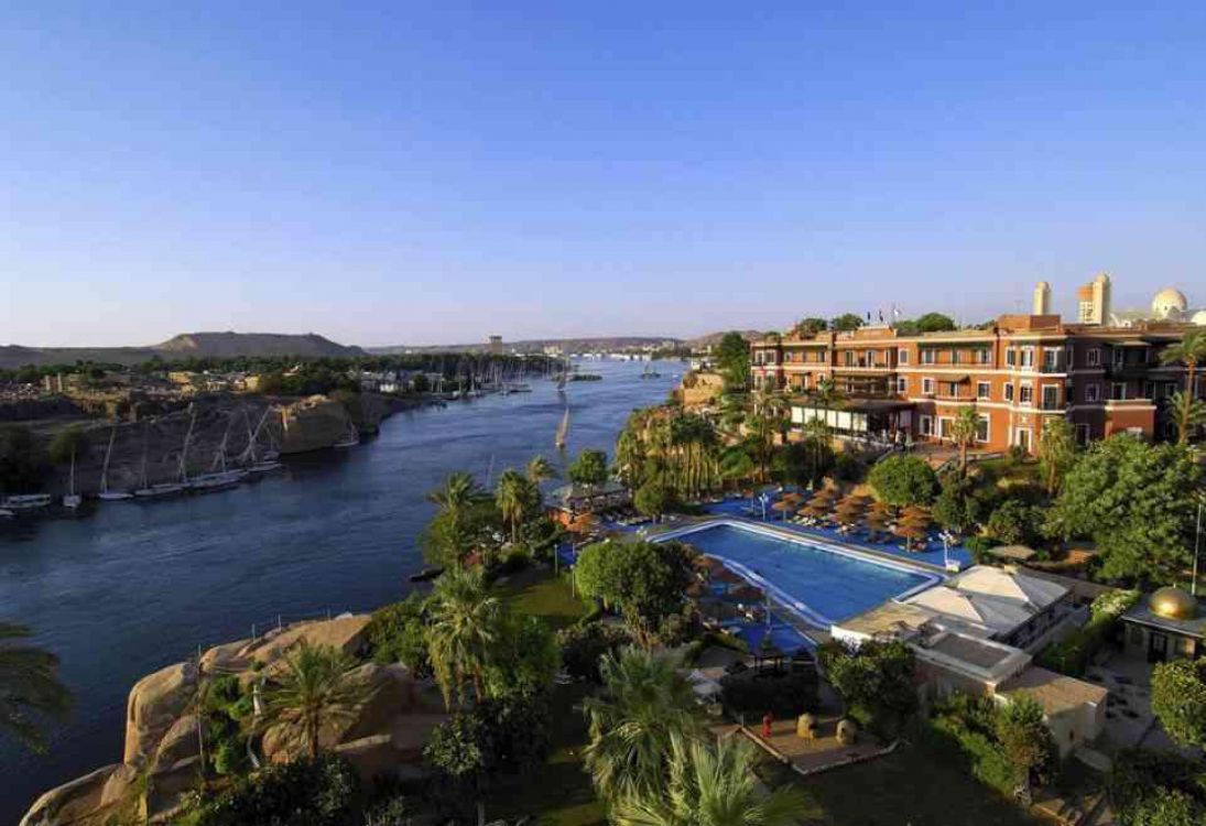 Bâtiment en Béton Brun Près D'un Plan D'eau Pendant la Journée. Wallpaper in 2999x2053 Resolution