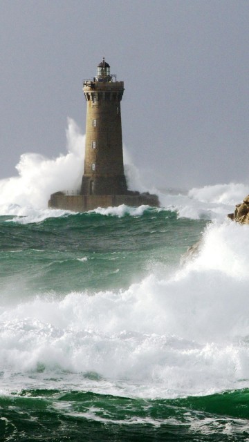 Image brown and white lighthouse on top of the hill