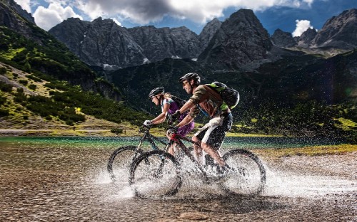 Image 2 men riding bicycle on river during daytime