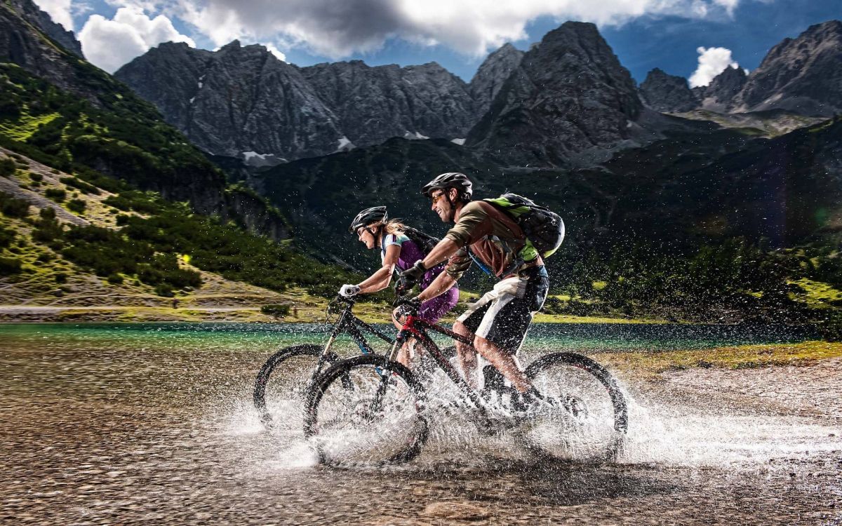 2 men riding bicycle on river during daytime