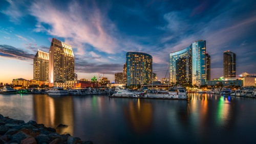 Image city skyline across body of water during night time