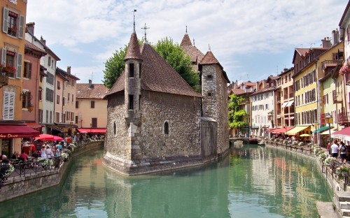 Image brown and gray concrete building beside river under blue sky during daytime