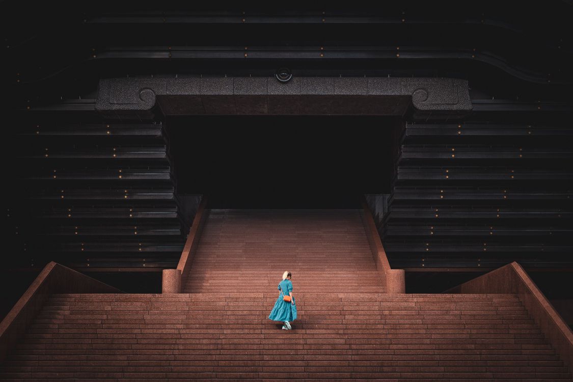 Frau in Blaugrünem Kleid Geht Auf Treppen. Wallpaper in 5472x3648 Resolution