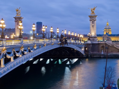 Image bridge over water near city buildings during night time