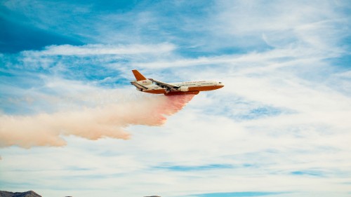 Image white and orange airplane in mid air during daytime