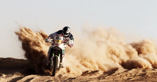 Image man riding motocross dirt bike on brown sand during daytime