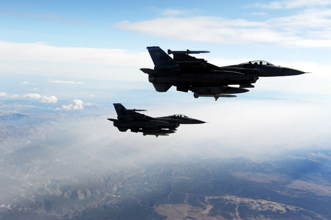 fighter jet flying over the clouds during daytime